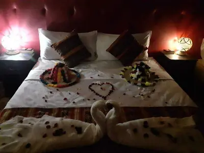 a bed with two plates of food on it at hostel sable dor merzouga in Merzouga