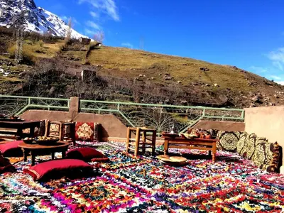 a large rug with flowers on it in front of a mountain at Gite entre les deux vallées in Tacheddirt