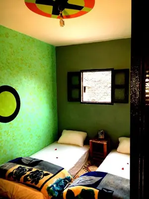 two beds in a room with green walls at Gite entre les deux vallées in Tacheddirt