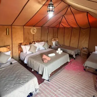 a bedroom with two beds in a tent at Luxury Merzouga Desert Camp in Merzouga