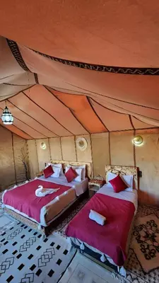 a bedroom with two beds in a tent at Luxury Merzouga Desert Camp in Merzouga