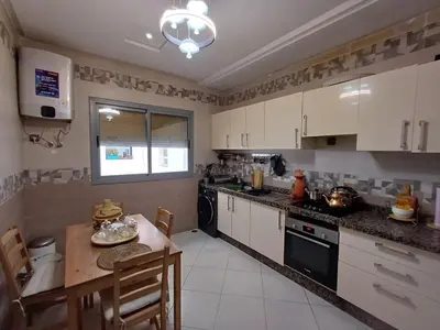 a kitchen with white cabinets and a small table and a tableablish at Dar serenity in Meknès