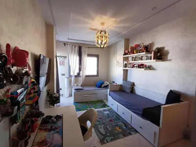 a small room with a bed and a refrigerator at Belle vacances dans mon App in Meknès