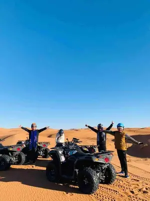 a group of people standing in the desert with their atvs at Sania Luxury Camp in Merzouga
