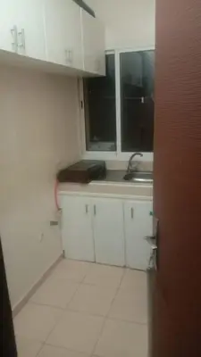 a kitchen with white cabinets and a sink at Vue Neige et Forêt Ifrane bien au chaud 3 pieces in Ifrane