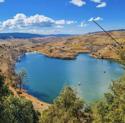 a view of a large lake in a valley at Auberge Sous Les Étoiles Lac Ouiouane in Kasba des Aït Athmane