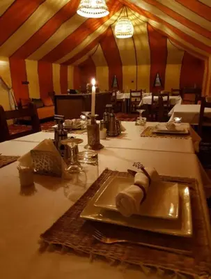 a table with a plate of food in a tent at Merzouga Marvelous Camp in Merzouga