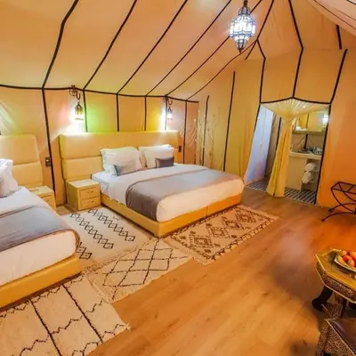 a bedroom with two beds in a tent at Dream Desert Camp in Merzouga
