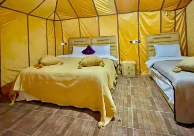 a bedroom with two beds in a tent at Mystic Dunes Camp & desert activities in Merzouga