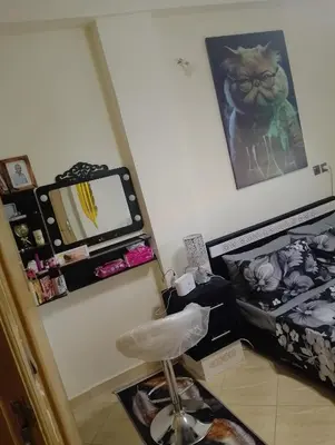a room with a bed and a desk with a mirror at Appartement Fadila in Fès