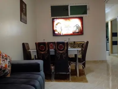 a living room with a table and a couch at Appartement Fadila in Fès