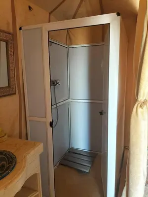 a shower in a room with a glass door at Magnifique Luxury Camp in Merzouga