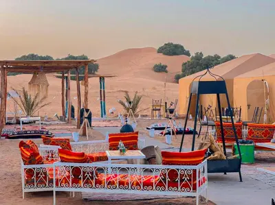 a group of chairs and tables in the desert at Tenere desert luxury camp in Merzouga