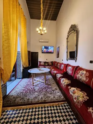 a living room with a red couch and a table at Dar Zerbtana suite Kenza in Fès