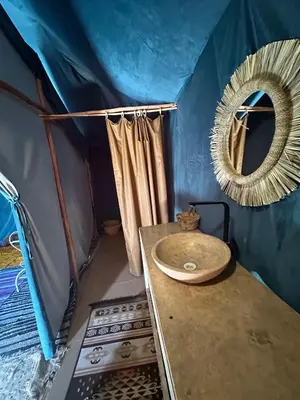 a bathroom with a sink and a mirror in a tent at Desert Nomads Camp in Merzouga