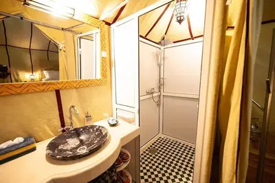 a bathroom with a sink and a shower at Desert Night Luxury Camp in Merzouga