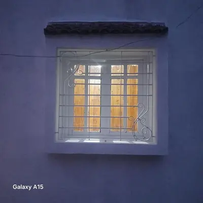a window of a building with bars on it at Maison d'Azur in Sidi Abdalwahad