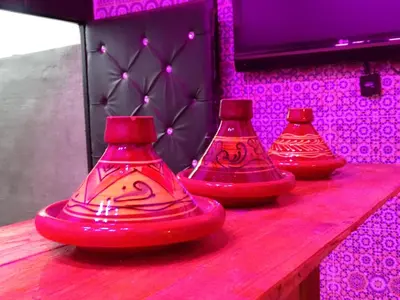 three red vases sitting on top of a wooden table at el habib in Fès