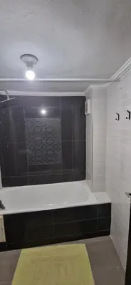 a bath tub in a bathroom with a green rug at Appartement de charme in Fès