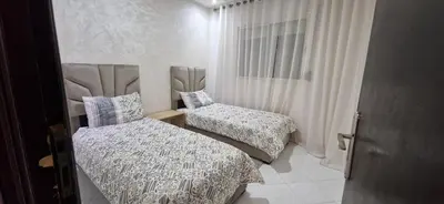 a bedroom with two beds and a window at Cozy apartment in Fès