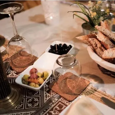 a table with a plate of bread and a bowl of fruit at Merzouga Queen Luxury Camp in Merzouga