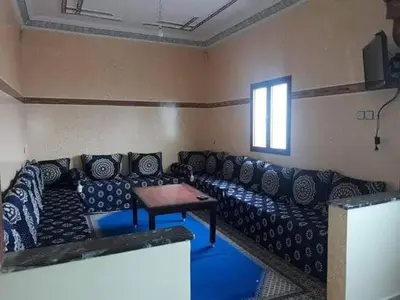 a living room with a couch and a table at Merzouga camp activités in Merzouga