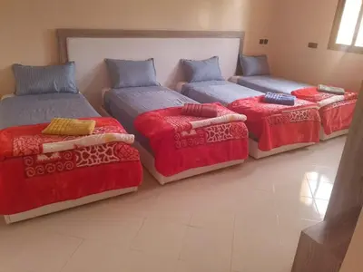 a room with three beds and a couch at hotel DIJON ouzoud in Ouzoud