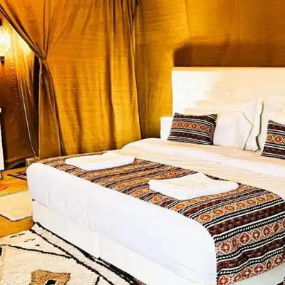 a bed with two white pillows on top of it at Sahara Starlight Luxury Camp in Merzouga