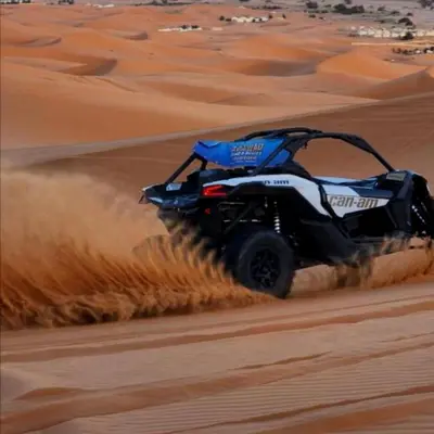 a atv driving through the sand in the desert at Merzouga Stars Luxury Camp in Merzouga