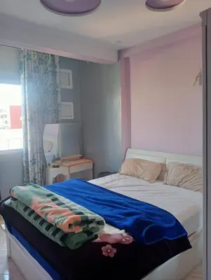 a bedroom with a bed with a blue blanket on it at Malak in Taza