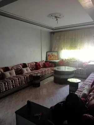 a living room with couches and a table at Malak in Taza