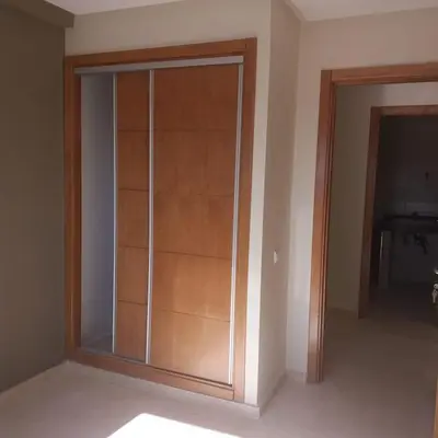 a large glass closet in the corner of a room at Appartement á Loisis á Bensimane in Oulad Akkou