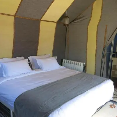 a bedroom with a large bed in a tent at Yamanda luxury camp in Merzouga
