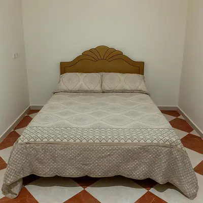 a bed in a bedroom with a bedspread on it at Résidence Kawtar Meknès in Meknès