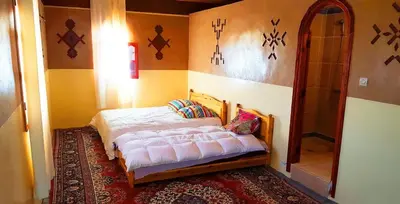 a bedroom with a bed in the corner of a room at Hotel Boutaghrar in Kalaat MGouna