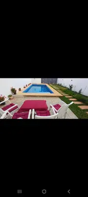 two pictures of a pool with chairs and a swimming pool at فيلا فاخرة in Imouzzer Kandar