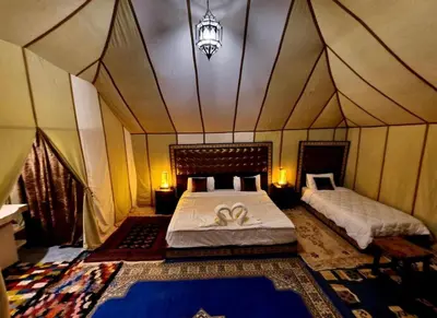 a bedroom with two beds in a tent at Fantastic Luxury Camp in Merzouga