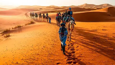 a group of people riding horses in the desert at Camp fire Dreams in Merzouga