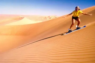 a woman riding on top of a sand dune in the desert at Desert camp nights camel ride in Merzouga