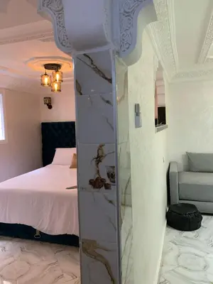 a bedroom with a bed and a mirror in a room at Appartement bel kayed in Fès