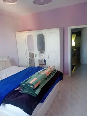 a bedroom with a bed with a blue blanket on it at Kinan in Taza