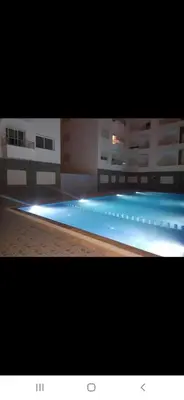a large swimming pool with lights in a building at Appartement à côté la plage in Oulad Akkou
