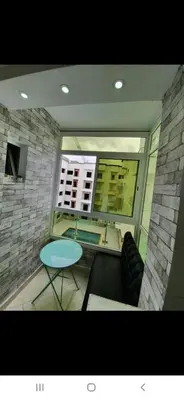 a view of a living room with a table and a window at Appartement à côté la plage in Oulad Akkou