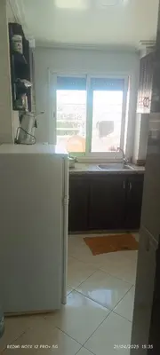 a kitchen with a refrigerator and a window at apartment raha in Oulad Akkou