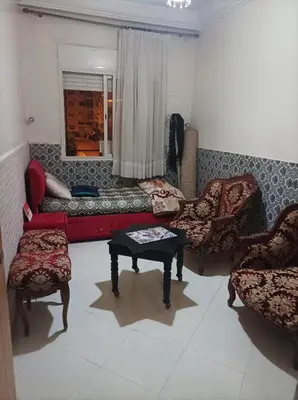 a living room with a couch and chairs and a table at Appartement La Joie in Oulad Akkou