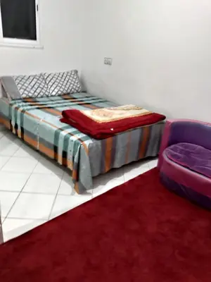 a bed and a chair in a room at Ikamat nakhil in Oulad Akkou