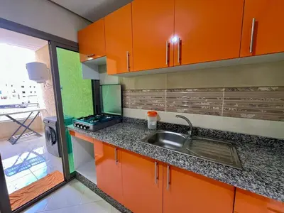 a kitchen with orange cabinets and a sink at Residence Noor - Central Apartments Fes in Fès