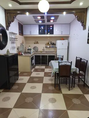 a kitchen with a table and chairs and a table and a kitchen at Farah in Oulad Akkou