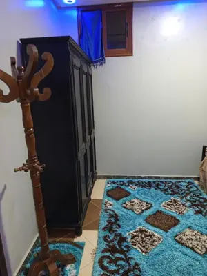 a room with a black cabinet and a blue rug at Farah in Oulad Akkou