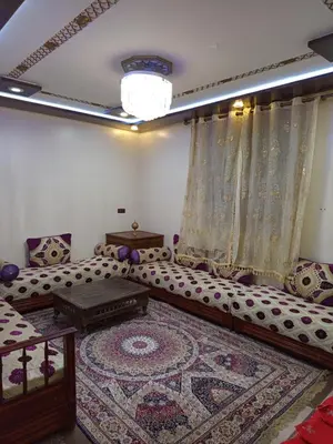 a living room with a couch and a rug at Farah in Oulad Akkou